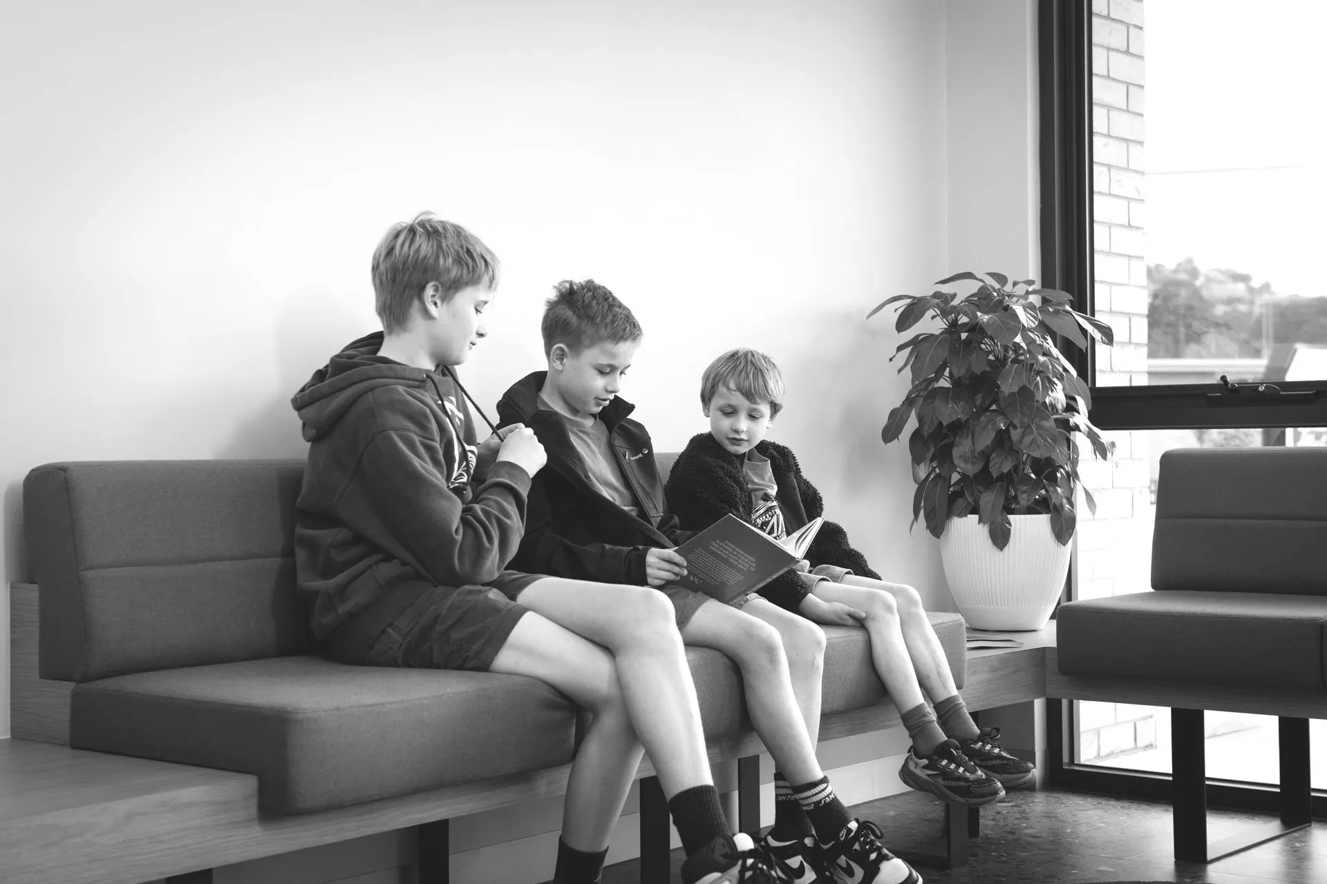 Three children reading together in the Dental.Affect waiting area