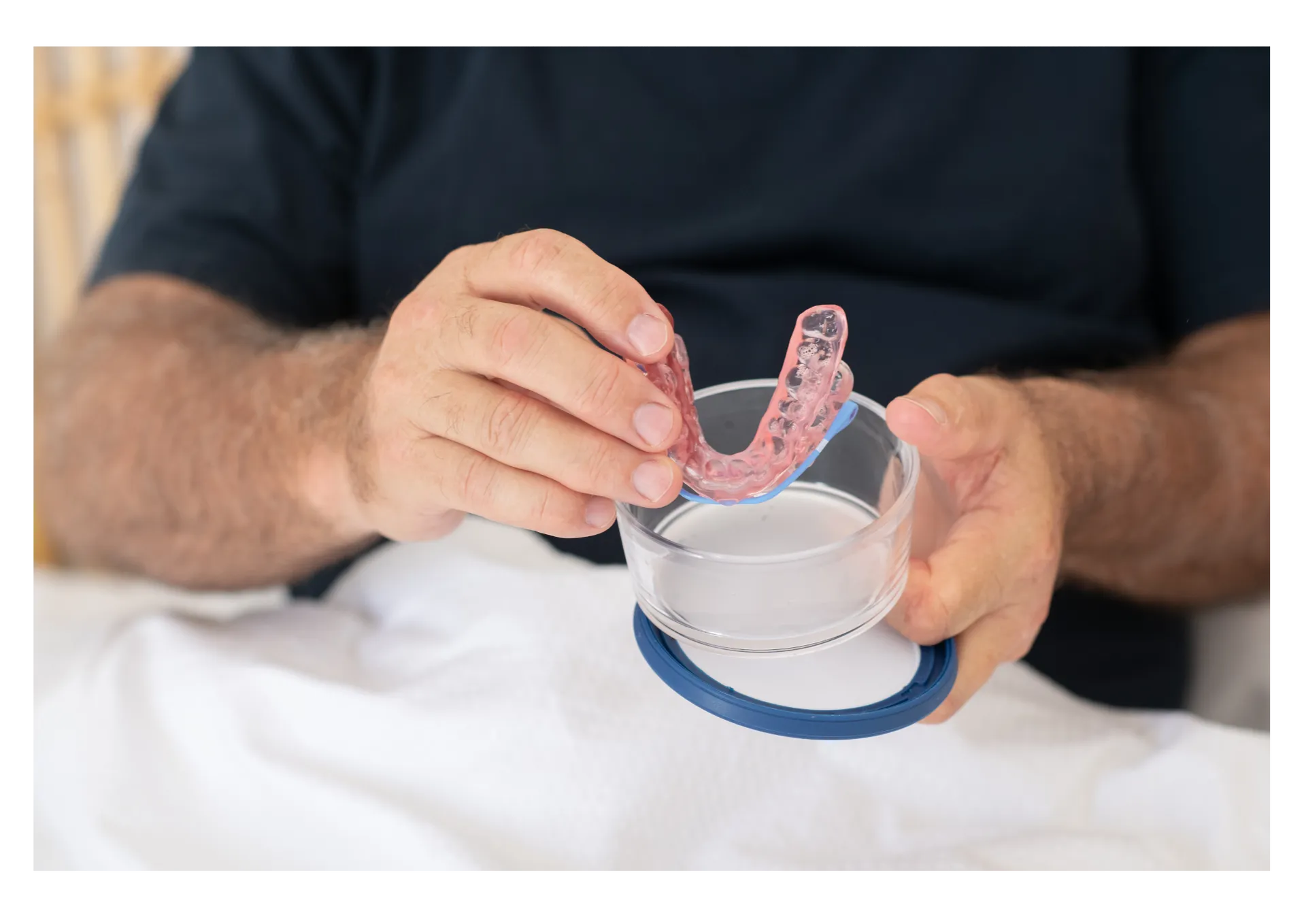 A patient placing a SomnoMed oral appliance into its case